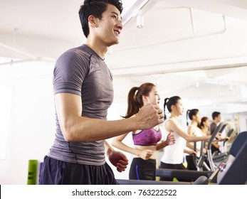 Young Asian Adult Working Out On Treadmill.