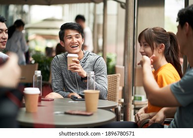 young asian adults men and woman sitting chatting relaxing in outdoor coffee shop - Powered by Shutterstock