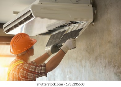 A Young Asian Air Conditioner Technician Or Air-conditioning Installation Technician Is About To Repair Air Conditioning In Homes And Buildings.Air Conditioner Repairmen Work On Home Unit. 
