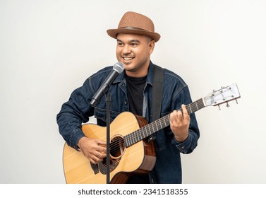 Young asian artist musician playing guitar in white studio. Relaxing with song and music. Asian man having fun playing acoustic guitar singing song - Powered by Shutterstock