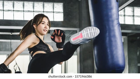 Young Asian Athlete Fitness Woman With Boxing Gloves Doing Kick Boxing Training In Sport Gym