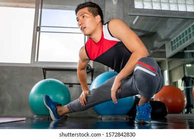 Young Asian attractive man stretching at fitness gym.