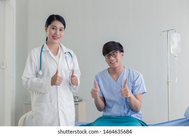 Young Asian Beautiful Doctor And Asian Teenage Patient Showing Thumbs Up With Happy Smiley Face In The Hospital.