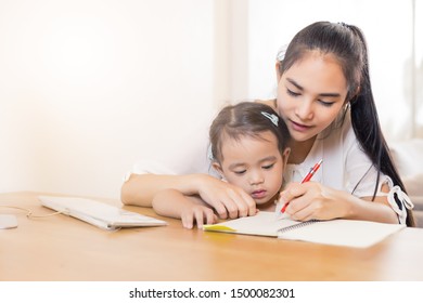 Young Asian Beautiful Mom With Her Daughter Kid Working At Home.