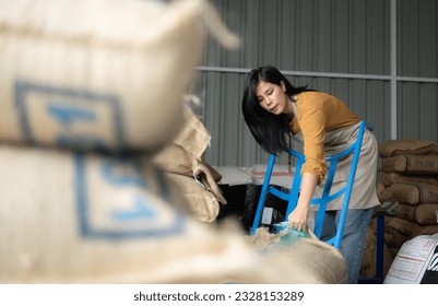 Young asian beautiful woman in coffee green bean bag factory, Happiness and confident in coffee industrial business and job success concept - Powered by Shutterstock