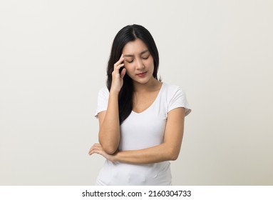 Young asian beautiful woman hand touching head she's feeling depressed stress headache be tired from working standing on isolated white background she has symptom office syndrome. - Shutterstock ID 2160304733