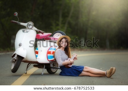 Young Asian beautiful woman joyful with ukulele sitting relaxing and motorcycle on the road