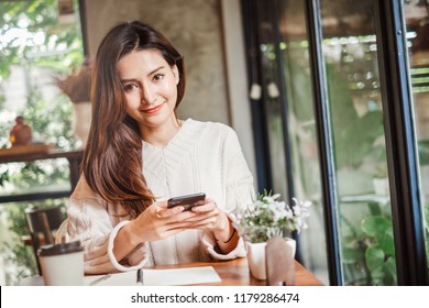 Young Asian Beautiful Woman Using Smart Phone For Business, Online Shopping, Transfer Money, Financial, Internet Banking. In Coffee Shop Cafe