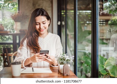 Young Asian beautiful woman using smart phone for business, online shopping, transfer money, financial, internet banking. in coffee shop cafe