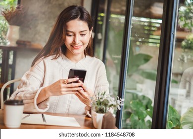 Young Asian Beautiful Woman Using Smart Phone For Business, Online Shopping, Transfer Money, Financial, Internet Banking. In Coffee Shop Cafe