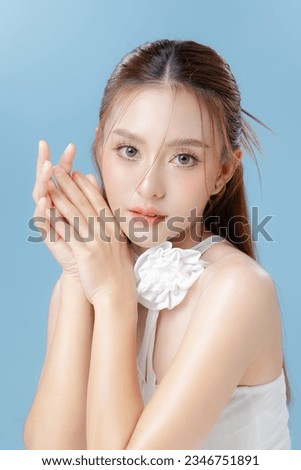 Young Asian beauty woman model long hair with natural makeup look on face and perfect clean skin on isolated blue background. Facial treatment, Cosmetology, Spa, Aesthetic, plastic surgery.