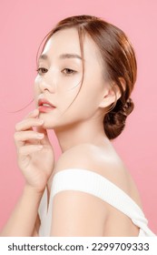 Young Asian beauty woman pulled back hair with korean makeup style touch her face and perfect skin on isolated pink background. Facial treatment, Cosmetology, plastic surgery. - Shutterstock ID 2299709333