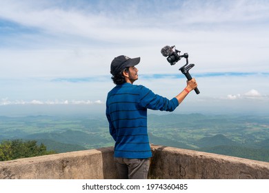 Young asian blogger or vlogger looking at camera and talking on video shooting with technology. Social media influencer people or content creator.