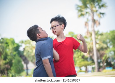 Young asian boy bullying a boy in park