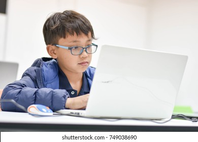 The young Asian boy is coding his game in the coding for kid class in Thailand.