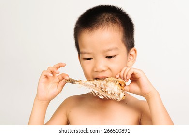 Young Asian Boy Eating Fish Showing Bone On White Background