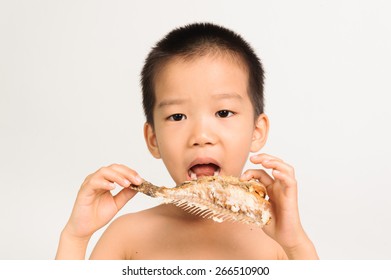 Young Asian Boy Eating Fish Showing Bone On White Background