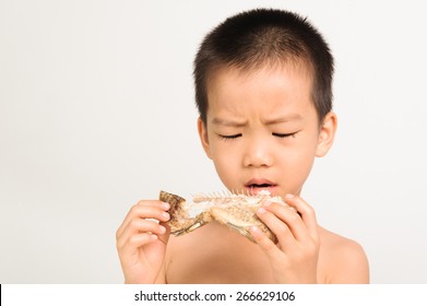 Young Asian Boy Eating Fish Showing Bone On White Background