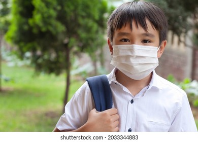 Young Asian Boy In Mask And A Uniform With A Backpack Outdoors. Back To School.