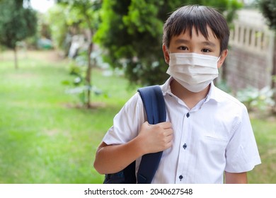 Young Asian Boy In Mask And A Uniform With A Backpack Outdoors. Back To School.