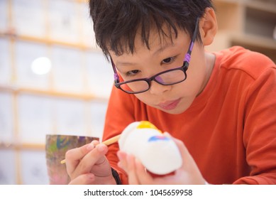 Young asian boy painting craft by color brush in classroom at school - Powered by Shutterstock