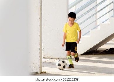 Young Asian Boy Play Football In The Empty White Building.