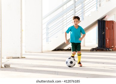 Young Asian Boy Play Football In The Empty White Building.