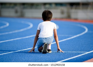 Young Asian Boy Prepare To Start To Run On A Blue Track In Summer Day