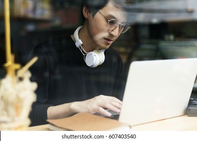 Young Asian Boy Wearing Hoodie Using Digital Laptop