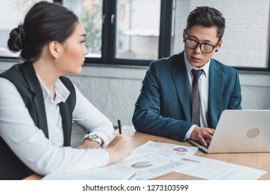 young asian business colleagues working with papers and laptop in office - Shutterstock ID 1273103599