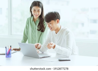 Young Asian Business Couple Working Together, Completing The Assigned Work