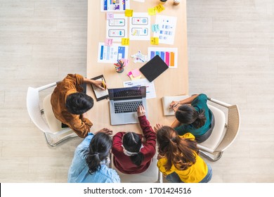 Young Asian business creative team work together using laptop computer, mobile application software design project. Brainstorm meeting, internet technology, office coworker teamwork concept. Top view - Shutterstock ID 1701424516