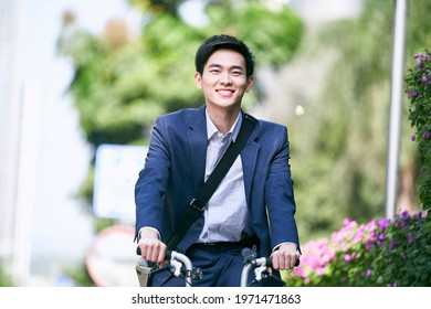 young asian business executive commuting by bike happy and smiling - Powered by Shutterstock