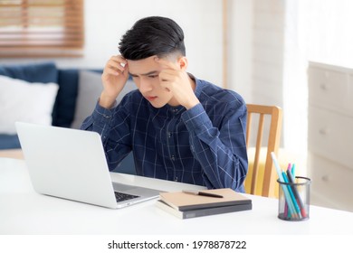 Young Asian Business Man Headache During Working On Laptop Computer With Deadline On Desk At Home, Businessman With Failure Exhausted And Tired, Stress And Worried, Frustrated And Unsuccessful.