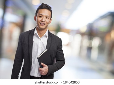 young asian business man holding a book