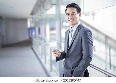 Young Asian Business Man Smile Holding Smart Phone At Office Area,man Smart Business Concept.