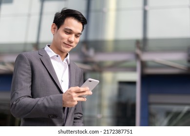 Young Asian Business Man Smile Holding Smart Phone At Office Area,man Smart Business Concept.
