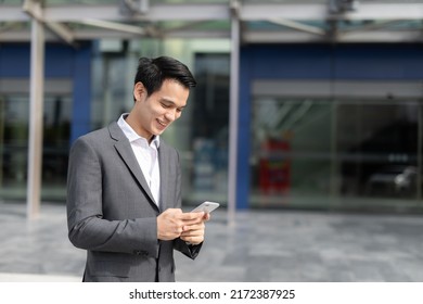 Young Asian Business Man Smile Holding Smart Phone At Office Area,man Smart Business Concept.
