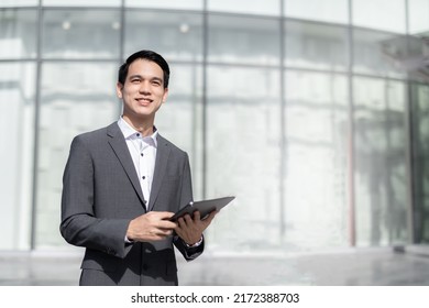 Young Asian Business Man Smile Holding Tablet At Office Area,man Smart Business Concept.
