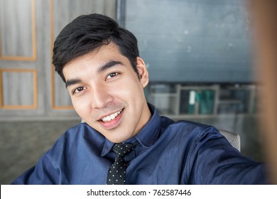 Young asian business man take a self portrait with her smart phone Asian man selfie in his office. Technology connected people man lifestyle concept 