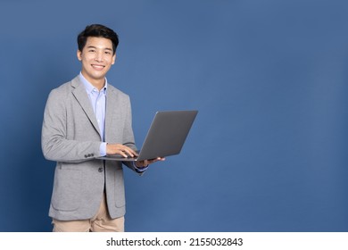 Young Asian Business Man Using Laptop Computer And Looking At Camera Isolated On Blue Background