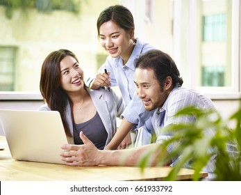 Young Asian Business People Team Working Together In Office Using Laptop Computer.