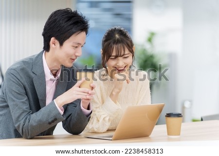 young asian business people using laptop together in a office