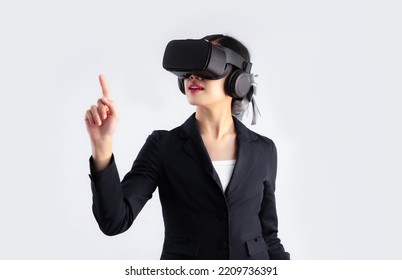 Young asian business woman in black suit wearing vr goggles headset posing finger pointing and touching on white background. Metaverse concept. - Powered by Shutterstock