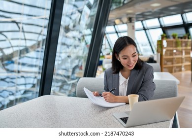 Young Asian business woman employee or executive manager using computer looking at laptop and talking leading hybrid conference remote video call virtual meeting or online interview working in - Powered by Shutterstock