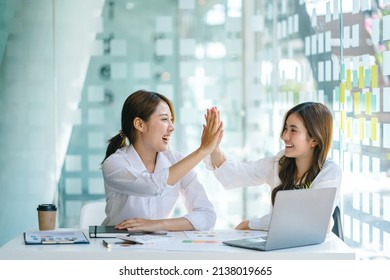 Young Asian Business Woman Giving High Five With Friends While Working With Computer Laptop At Office.