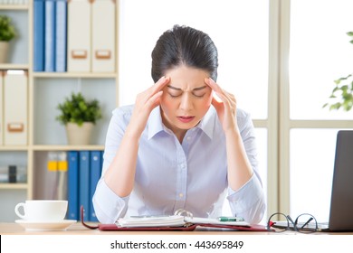 Young Asian Business Woman With Headache In Office