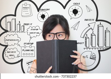 Young Asian Business Woman Holding A Book With Mixed Finance Business Doodles. Entrepreneurship Startup Business Concept