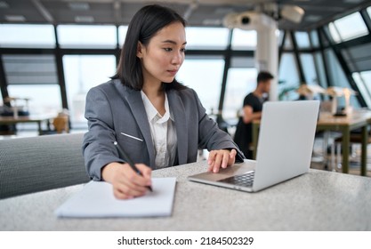 Young Asian business woman office employee using laptop watching webinar. Female professional worker, company manager working on computer online doing corporate data digital technology analysis. - Powered by Shutterstock