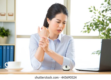 Young Asian Business Woman With Pain In Wrist In Office